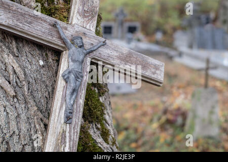 Gesù Cristo scultura su una croce di legno al cimitero di Bialowieza, Polonia orientale. Foto Stock