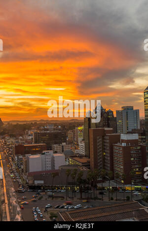 Un tramonto è visto oltre il Harare skyline della città in Zimbabwe Foto Stock
