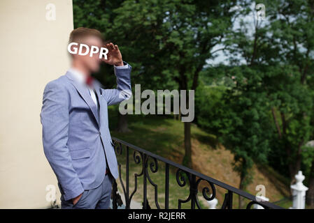 Il PILR, uomo in tuta sorge sul balcone e appare in lontananza si copre il viso con la sua mano. Foto Stock