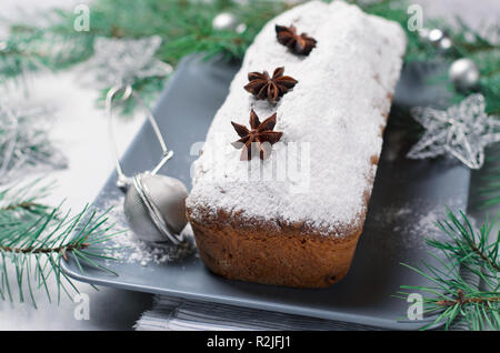 Torta di pane spolverata con zucchero a velo, le vacanze di Natale ed invernali trattare, fatti in casa Ciambellone su sfondo grigio Foto Stock