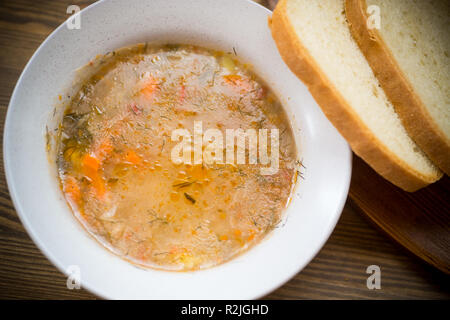 Zuppa di magro con le verdure e le semole in una piastra su un tavolo di legno Foto Stock