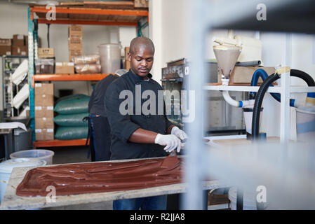 Cioccolato artigianale maker lavorando in una pasticceria rendendo la fabbrica Foto Stock