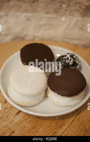 Eclairs al cioccolato e palle sul tavolo di legno Foto Stock