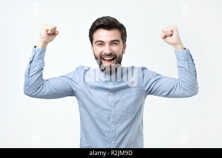 Ritratto di felice uomo spagnolo con i pugni fino per celebrare la sua vittoria Foto Stock