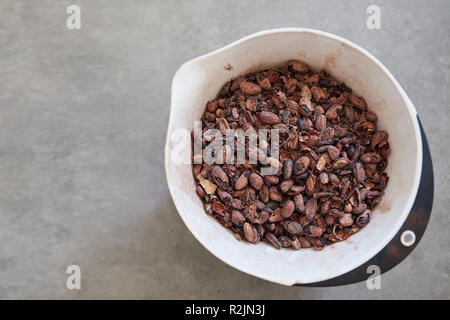 Le fave di cacao pesato in un cioccolato artigianale rendendo la fabbrica Foto Stock