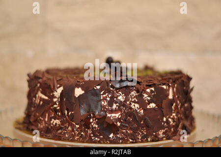 Delizioso cioccolato fresco Pistaccio torta con pezzetti di cioccolato intorno e pistacchi e servite sulla piastra di vetro con decorazione di Natale Foto Stock