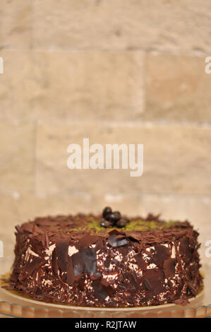 Delizioso cioccolato fresco Pistaccio torta con pezzetti di cioccolato intorno e pistacchi e servite sulla piastra di vetro con decorazione di Natale Foto Stock