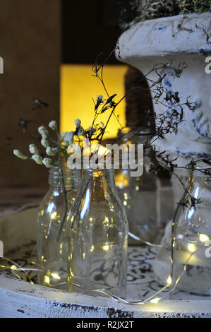 Natale Decorazioni per la tavola, bottiglie con rami di filigrana e le luci fairy Foto Stock