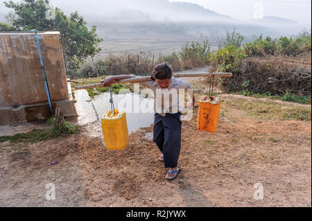 Giovane donna il prelievo di acqua da un pozzo nella regione di Taunggyi in Shan Myanmar Foto Stock