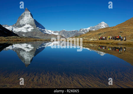 Vista sulla parte superiore Riffelsee vicino a Zermatt e il Cervino. A destra è la Dent Blanche e una partenza cinese gruppo turistico. Foto Stock