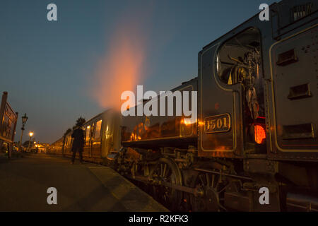 Locomotiva a vapore vintage UK accanto alla piattaforma, stazione ferroviaria di Severn Valley Kidderminster, in attesa di partenza. Il vapore che sale si illumina. Foto Stock