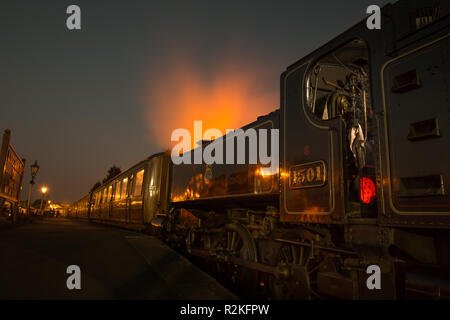 Vista laterale da vicino della locomotiva a vapore vintage del Regno Unito e delle carrozze dei treni vintage di notte che aspettano dalla piattaforma, la stazione ferroviaria di Severn Valley Kidderminster. Foto Stock