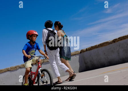 Un ragazzo su una bicicletta al sole con crash hat, casco su dalla costa spagnola. Foto Stock