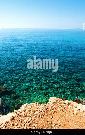 Sullo sfondo di un giallo e pietre bianche vicino increspata trasparente crystal clear incredibile verde e blu acqua sotto il blu cielo senza nuvole. Caldo somma senza nuvole Foto Stock