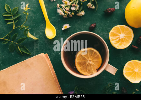 La medicina di erbe laici flat top view con tazza di calda tè di rosa canina e la fetta di limone Foto Stock