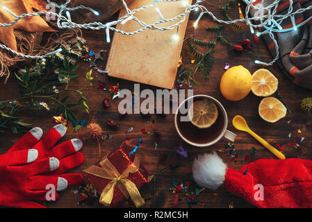 Nuovo anno e Natale laici flat top view con Santa Claus hat, confezione regalo e una tazza di tè. Felici vacanze invernali concetto. Foto Stock