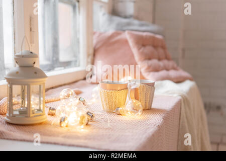 Maglia tazze di lana su un tavolo di legno. due tazze di caffè caldo. il concetto di calore. vacanze ed eventi. In autunno e in inverno, concetto di piacere. Accogliente e confortevole e morbido. Foto Stock