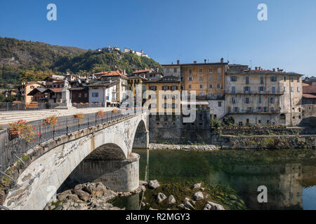 Ponte sul fiume Sesia, la vecchia città di Varallo, dietro il Sacro Monte Sacro Monte di Varallo (patrimonio mondiale UNESCO dal 2003), Varallo, provincia di Vercelli, Piemonte, Italia Foto Stock