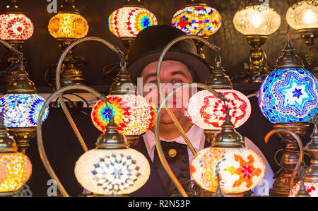 Gloucester, Gloucestershire, UK. Xix Nov, 2018. Gloucester Quays premiato Victorian Mercatino di Natale, il più grande entrata libera Victorian Mercatino di Natale nel sud-ovest. Mercato titolare di stallo del peering attraverso colorate luci decorative lampade per la vendita. Credito: Carolyn Jenkins/Alamy Live News Foto Stock