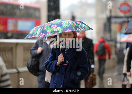 Westminster. Londra, Regno Unito. Xx Nov, 2018. Ufficio lavoratori riparo dalla pioggia sotto gli ombrelloni durante il diluvio a Londra in una fredda mattina. Secondo il Met Office, neve e grandine arriverà in Gran Bretagna questa settimana come temperature cadono. Credito: Dinendra Haria/Alamy Live News Foto Stock