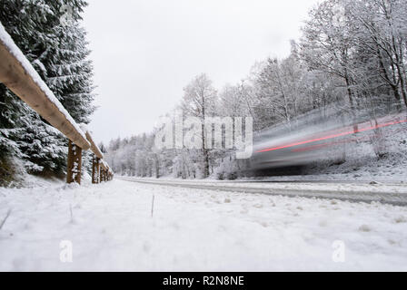 East Westfalia, Germania. Il 20 novembre 2018, Renania settentrionale-Vestfalia, Bad Wünnenberg: un auto drive su una fresca coperta di neve su strada attraverso un pezzo di bosco al Aabachtalsperre. Foto: Guido Kirchner/dpa Credito: dpa picture alliance/Alamy Live News Foto Stock