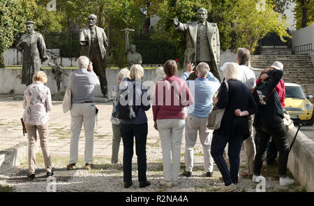 Tirana, Albania. 28 ott 2018. I turisti fotografare le figure in bronzo di Josef Wissarionowitsch Stalin (l, r), Vladimir Iljitsch Lenin (M) e il busto di pietra di Enver Hoxha (secondo da destra) sulla zona esterna della Galleria Nazionale. Tirana è la capitale dell'Albania. Credito: Pietro Endig/dpa-Zentralbild/ZB/dpa/Alamy Live News Foto Stock