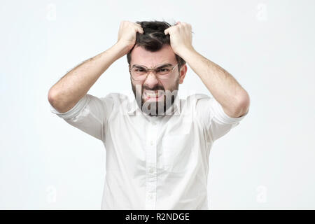 Arrabbiato uomo spagnolo tirando fuori i suoi capelli, essendo mad guardando con espressione furiosa Foto Stock