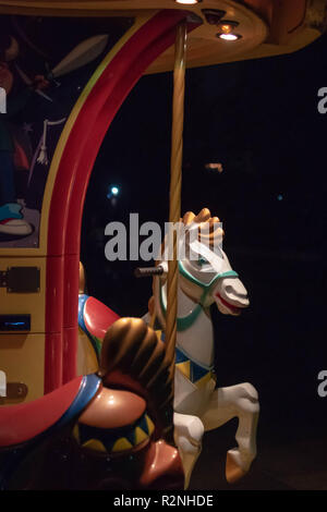 Tasto basso ingrandimento di un cavallo di un merry-go-round, con luce e shadown giocando sulle curve morbide del cavallo Foto Stock