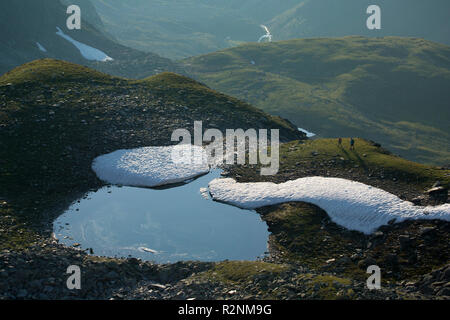 Gli escursionisti in un anonimo lago nella valle Riegetal, gamma Geigenkamm, Alpi Venoste, Tirolo, Austria Foto Stock