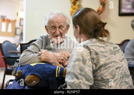 1Lt. Ashley Chapa, direttore di pari opportunità assegnato al centottantesimo Fighter Wing, parla con gli Stati Uniti Esercito la II Guerra Mondiale, veterano Rywalski romana, durante una cerimonia in onore di veterani in Swanton Healthcare & Centro di pensionamento in Swanton, Ohio, nov. 3. I membri con il 180FW Azienda funzionario di grado del consiglio locale ha visitato i veterani e li ha presentati con i certificati di onorare il loro servizio. Foto Stock