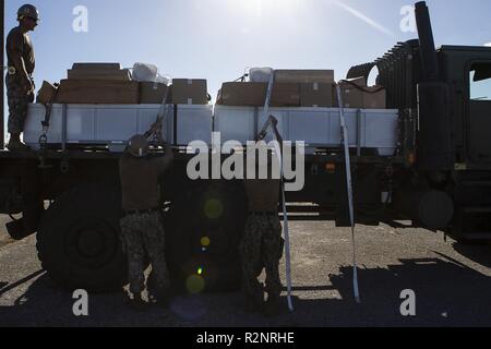 Stati Uniti Navy Seabees con Naval Mobile Battaglione di costruzione 1 secure U.S. Federal Emergency Management Agency tende ad un 7-ton carrello dello scanner a superficie piana al porto durante la U.S. Supporto per la difesa delle autorità civili soccorsi su Tinian, Repubblica della Mariana Islands settentrionale, nov. 5, 2018. Le aziende, gli edifici governativi, case e scuole sono state pesantemente danneggiata da Super Typhoon Yutu, che ha fatto un colpo diretto con effetti devastanti su Tinian ott. 25 come la seconda più forte tempesta per sempre colpito suolo americano. Marines con il trentunesimo Marine Expeditionary Unit e combattere il battaglione della logistica 31 è arrivato su Tinia Foto Stock