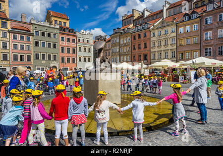 I bambini della scuola circondano la fontana con la bronce scultura della sirenetta di Varsavia da Konstanty Hegel sulla vecchia piazza del mercato, la 'Syrenka' ( Foto Stock