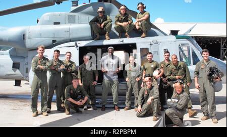 Attore Stephen Hill pone con Marines da Marina Attacco leggero elicottero Squadron 367 nella parte anteriore di un UH-1Y Huey, in Marine Corps base Hawaii, nov. 2, 2018. Hill gioca un ex marine Huey pilota come Theodore 'tc' Calvin sulla televisione mostra Magnum P.I. Foto Stock