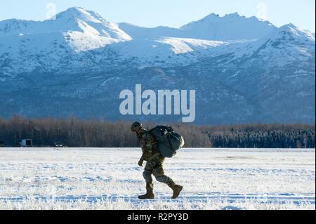 Un paracadutista assegnato alla quarta brigata di fanteria combattere Team (airborne), XXV divisione di fanteria, U.S. Esercito di Alaska, passeggiate ad un paracadute di punto di raccolta dopo lo svolgimento di una operazione di airborne Malemute sulla zona di caduta sulla giunzione base Elmendorf-Richardson, Alaska, nov. 1, 2018. I soldati sono parte di un gruppo di aerei con la possibilità di implementare rapidamente in tutto il mondo e sono addestrati per condurre operazioni militari in condizioni di austera. Foto Stock