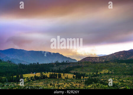 Vista in direzione di Ferguson fuoco appena al di fuori del Parco Nazionale di Yosemite; colorato nuvole di fumo che copre il sole; California Foto Stock