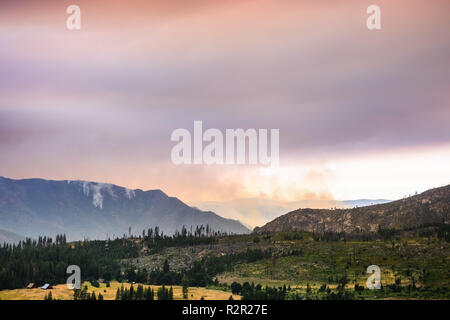 Vista in direzione di Ferguson fuoco appena al di fuori del Parco Nazionale di Yosemite; colorato nuvole di fumo che copre il sole; California Foto Stock