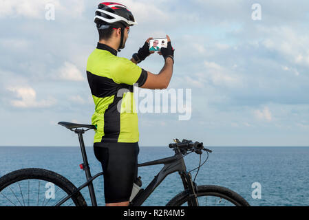 Ciclista parla al suo medico di chiamata video Foto Stock