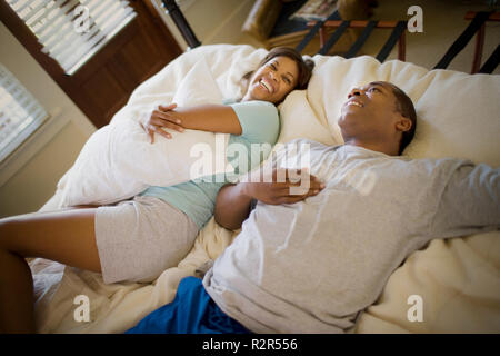 Mid-adulto giovane giacente su un letto insieme. Foto Stock