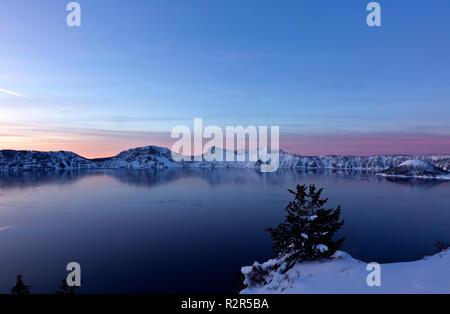 OREGON - una fredda alba dal punto di pomice area su un ghiaccio lago scimmed a Wizared isola, e Rim Village; Parco nazionale di Crater Lake. Foto Stock