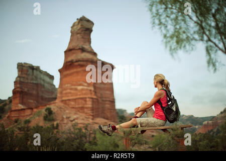 Giovane donna si prende una pausa da escursionismo a guardare il panorama del canyon. Foto Stock