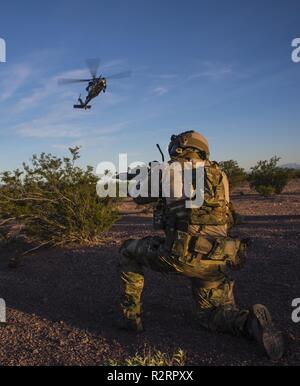 Un U.S. Air Force pararescueman con la 66squadrone di salvataggio attende per un HH-60 Pave Hawk per terra durante la lotta contro la ricerca e la formazione di soccorso per il salvataggio di Tiger vi esercizio in Tucson, Arizona, nov. 3, 2018. Tiger Rescue riunisce squadroni e attività che ricadono sotto il 563rd Gruppo di salvataggio al fine di eseguire vari esercizi CSAR. Foto Stock