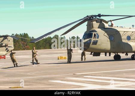 Stati Uniti I soldati dell esercito assegnato al Bravo Company, 3° supporto generale battaglione, ottantaduesima reggimento di aviazione, ottantaduesima Airborne Division combattere la Brigata Aerea, legare le pale di un CH-47 elicottero Chinook dopo il ritorno da un combinato di bracci live-fire esercitare sulla Fort Bragg, North Carolina, nov. 7, 2018. Le lame sono td come post-funzione di volo per evitare che parti di aerei di muoversi mentre gli equipaggi non è sul velivolo. Foto Stock