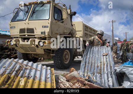 Guam Esercito Nazionale Guardsman Spc. Ryan Jimmy, 1224th ingegnere società di supporto di attrezzature pesanti, l'operatore rimuove coperture in metallo dal lato della strada nel villaggio di Chalan Kanoa, Saipan, Repubblica della Mariana Islands settentrionale, nov. 9, 2018 come parte del Super Typhoon Yutu soccorsi. I membri del servizio dalla regione di giunzione e Marianne U.S. Comando Indo-pacifico stanno fornendo il Dipartimento della Difesa supporto alla CNMI's civile e funzionari locali come parte del FEMA-supportato Super Typhoon Yutu gli sforzi di recupero. Foto Stock