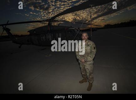 Stati Uniti Il personale dell'esercito Sgt. Simon D. Debran, un UH-60L Black Hawk meccanico in elicottero dall'1-150th elicottero d'assalto battaglione, si distingue per un ritratto all'esercito Aviation Support Facility, Base comuneGuire-Dix Mc-Lakehurst, N.J., nov. 8, 2018. Foto Stock