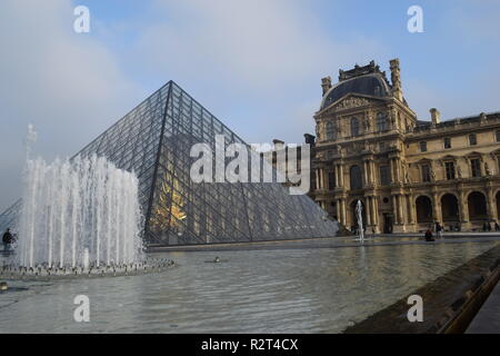 La piramide di vetro e una fontana nel cortile del Palais du Louvre, Parigi, Francia Foto Stock