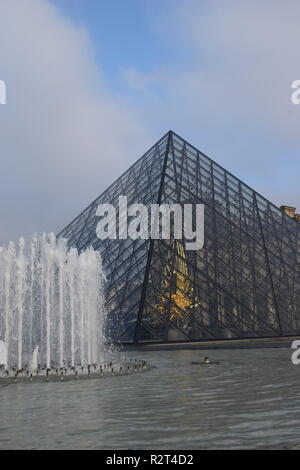 La piramide di vetro e una fontana nel cortile del Palais du Louvre, Parigi, Francia Foto Stock