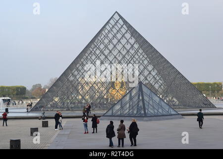 I turisti davanti alla piramide in vetro presso il Museo del Louvre il Musée du Louvre di Parigi Francia, il più famoso per il Codice Da Vinci. Foto Stock