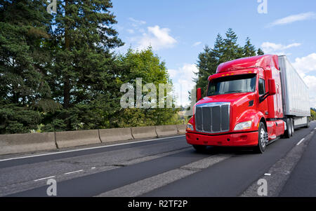 Rosso brillante cofano americano moderno long haul big rig semi carrello con dry van semi rimorchio trasporto commerciale cargo in movimento sulla vasta multiline gr Foto Stock