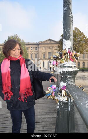 I popoli sul Pont des Arts passerella sul fiume Senna e la gente a piedi attraverso un ponte pedonale sul Fiume Senna di fronte al museo del Louvre Foto Stock