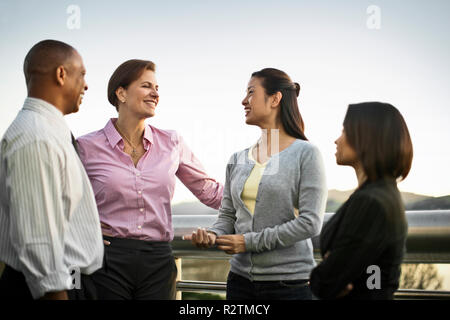 Colleghi di lavoro a parlare insieme su un balcone. Foto Stock